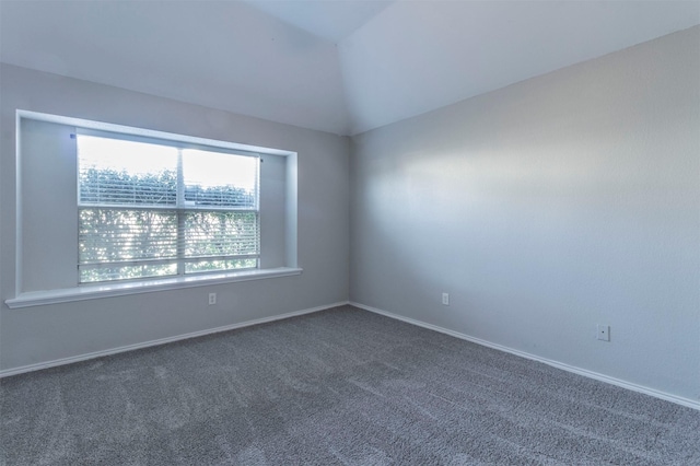 carpeted empty room with lofted ceiling