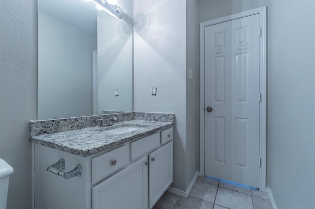 bathroom with tile patterned flooring, vanity, and toilet