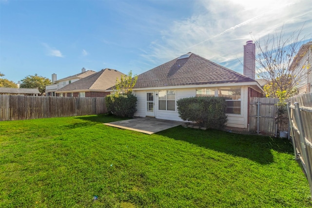 rear view of house featuring a yard and a patio