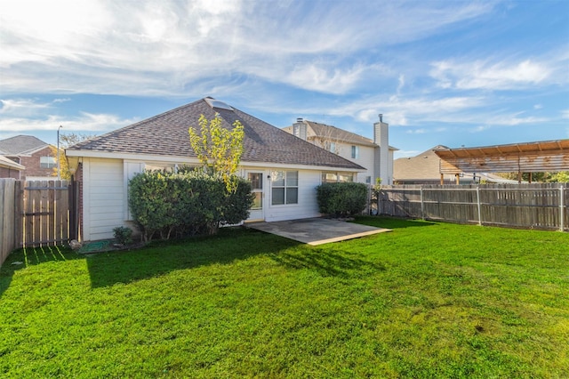 back of property with a yard and a patio area