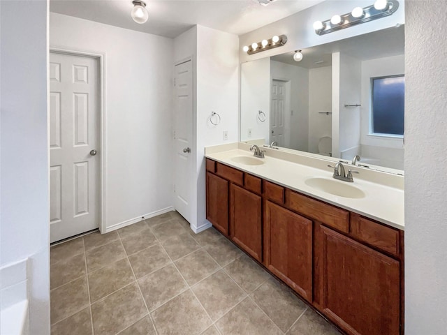 bathroom with vanity, tile patterned flooring, and a tub