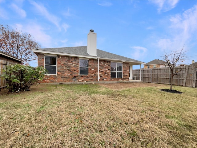 rear view of property with a lawn