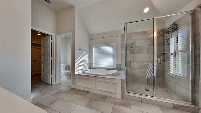 bathroom featuring lofted ceiling, tile patterned floors, plus walk in shower, and toilet