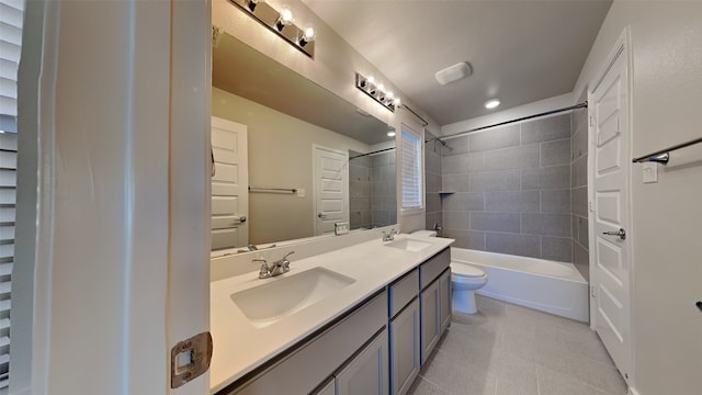 full bathroom with vanity, tiled shower / bath combo, tile patterned floors, and toilet