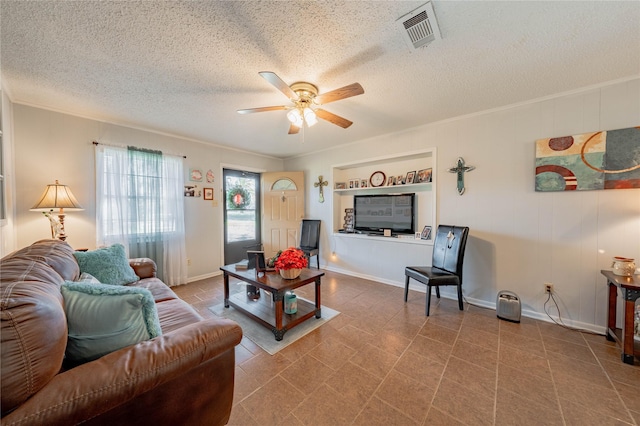 living room with a textured ceiling, ceiling fan, and crown molding