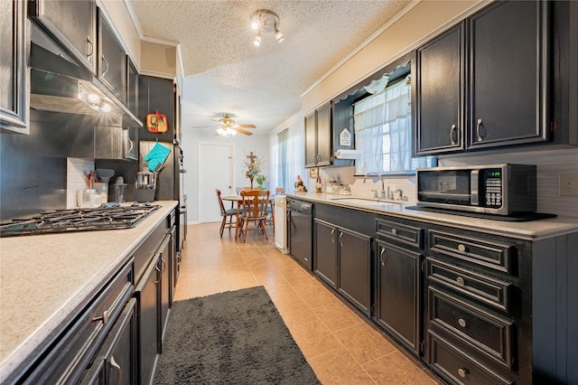 kitchen featuring a textured ceiling, backsplash, stainless steel appliances, and sink