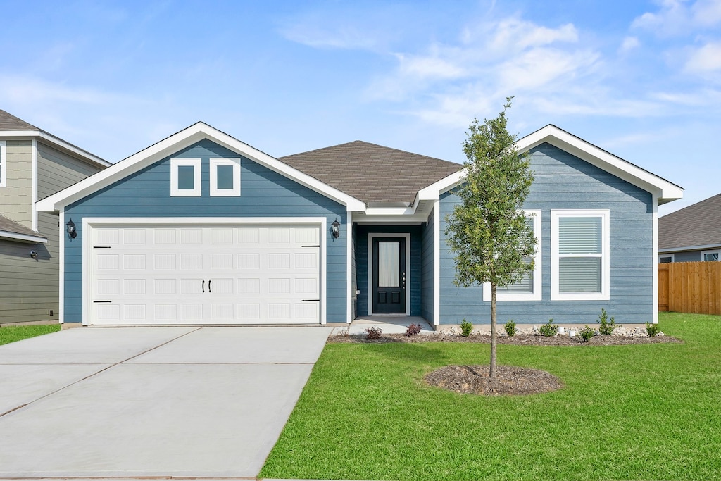 view of front of home with a garage and a front lawn