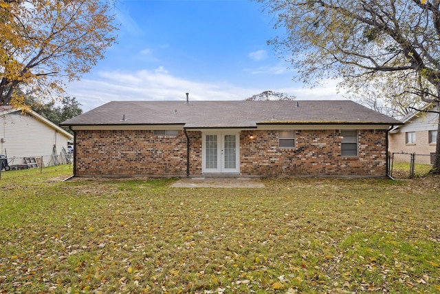 back of house featuring french doors and a lawn