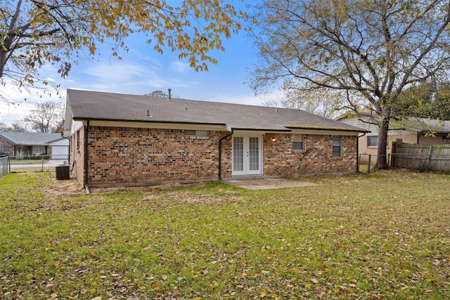 rear view of house featuring french doors, central AC, and a lawn