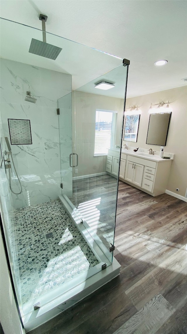 bathroom featuring vanity, wood-type flooring, and walk in shower