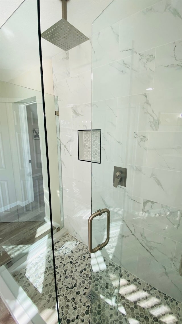 bathroom featuring a shower with door