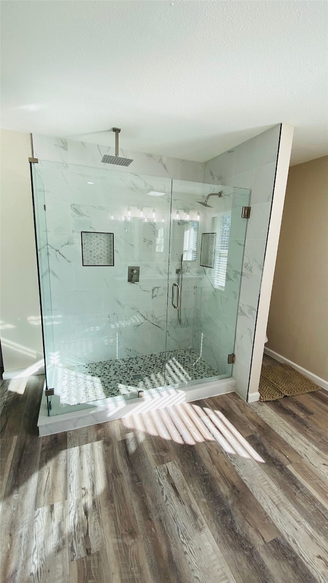 bathroom featuring hardwood / wood-style floors and a shower with door