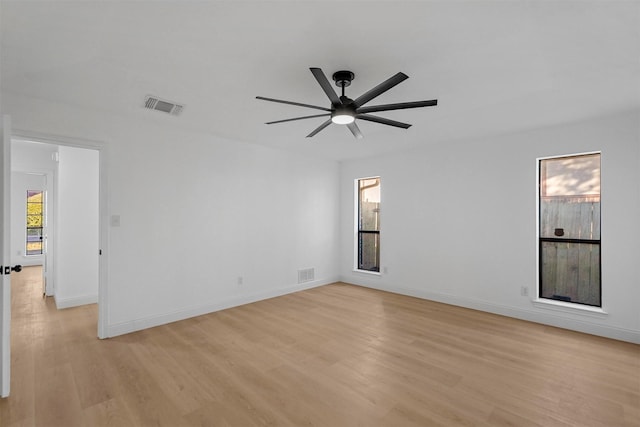 empty room with ceiling fan, light hardwood / wood-style floors, and plenty of natural light