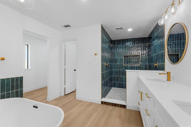 bathroom featuring hardwood / wood-style flooring, vanity, and separate shower and tub