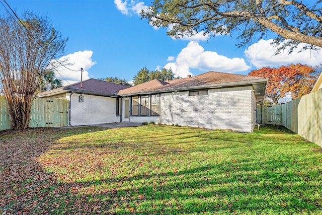 rear view of property featuring a lawn