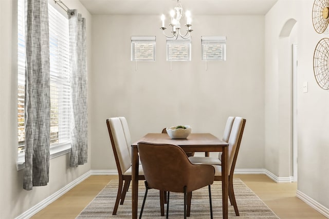 dining room with light wood-type flooring and an inviting chandelier