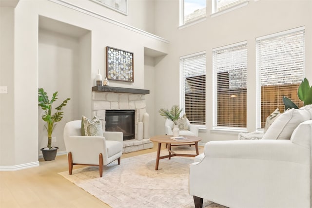 living room with hardwood / wood-style flooring, a fireplace, and a high ceiling