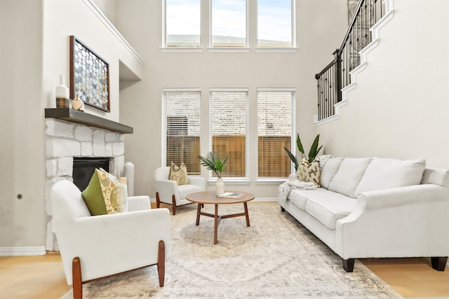 2053 Barx Dr, Little Elm, TX 75068 - living room with a stone fireplace, a high ceiling, wood finished floors, and baseboards