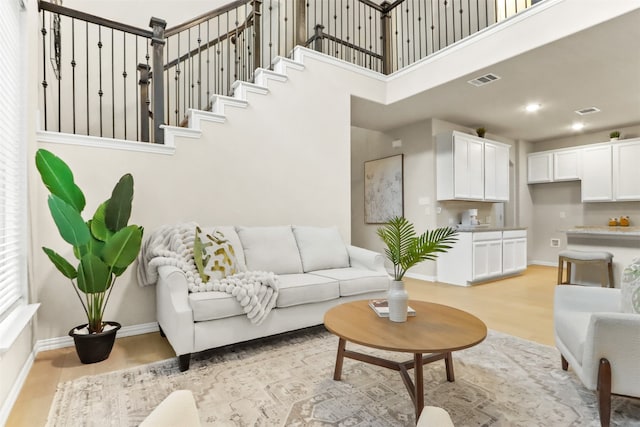 living room featuring a high ceiling and light wood-type flooring