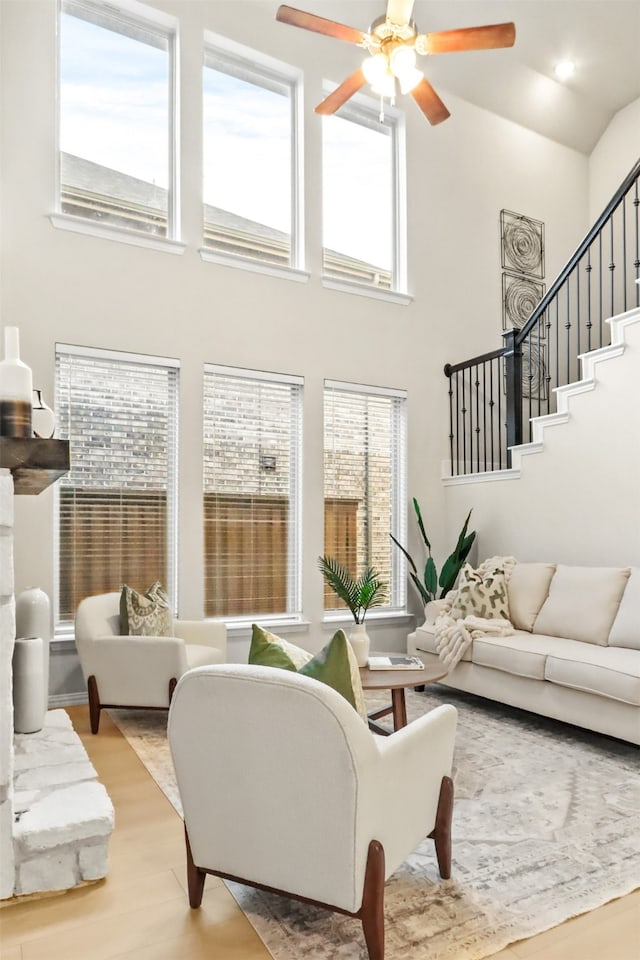 2053 Barx Dr, Little Elm, TX 75068 - living room featuring plenty of natural light, light wood-style floors, a towering ceiling, a ceiling fan, and stairway