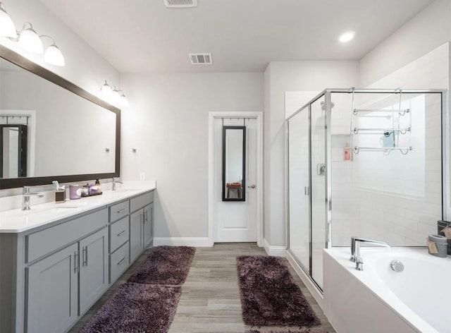 bathroom with hardwood / wood-style flooring, shower with separate bathtub, and vanity