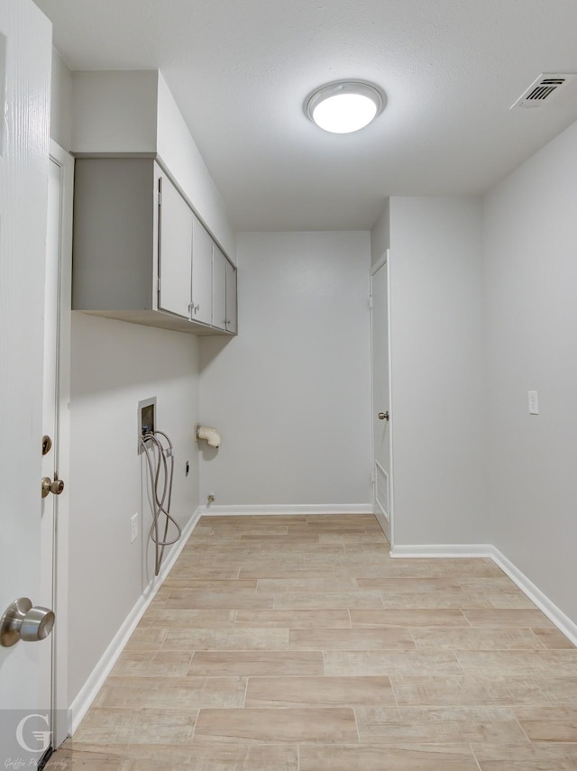 laundry room featuring gas dryer hookup, hookup for a washing machine, cabinets, and light hardwood / wood-style floors