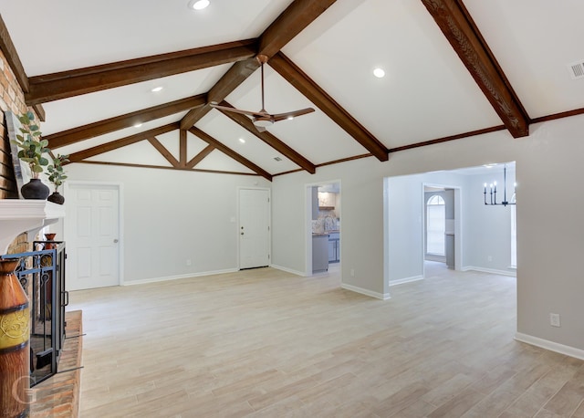 unfurnished living room with vaulted ceiling with beams, light wood-type flooring, ceiling fan with notable chandelier, and a brick fireplace