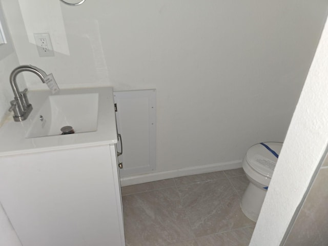 bathroom featuring tile patterned flooring, vanity, and toilet