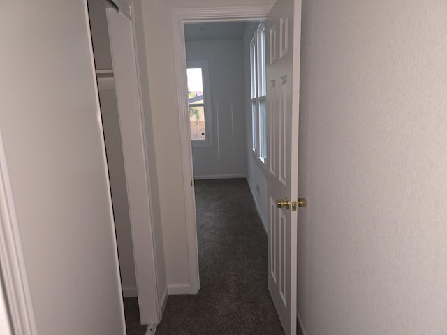 hall with dark colored carpet