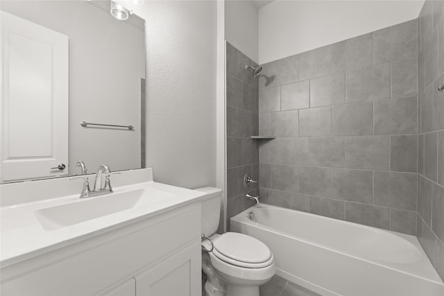 full bathroom featuring vanity, tiled shower / bath combo, and toilet