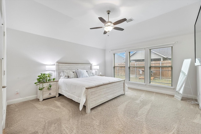 carpeted bedroom with ceiling fan and vaulted ceiling