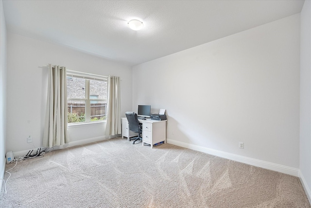 unfurnished office featuring light colored carpet and a textured ceiling