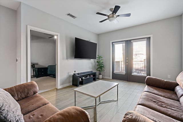 living room with ceiling fan, light hardwood / wood-style flooring, and french doors