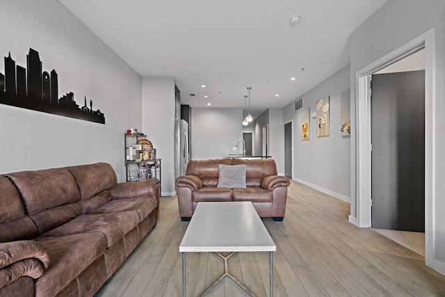 living room with light hardwood / wood-style flooring and sink