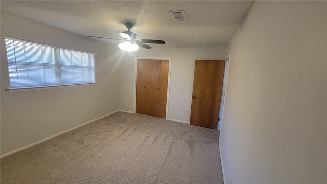 unfurnished bedroom featuring ceiling fan, carpet floors, a textured ceiling, and a closet