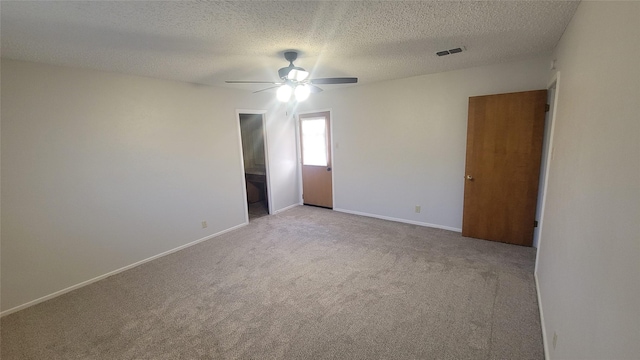 carpeted empty room with ceiling fan and a textured ceiling