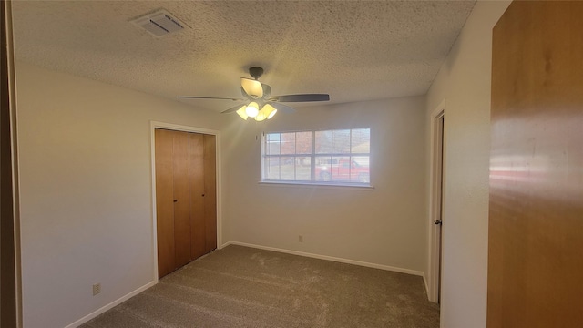 unfurnished bedroom with ceiling fan, carpet floors, a closet, and a textured ceiling