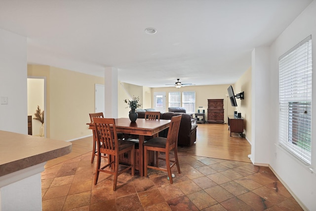 dining area with a ceiling fan and baseboards