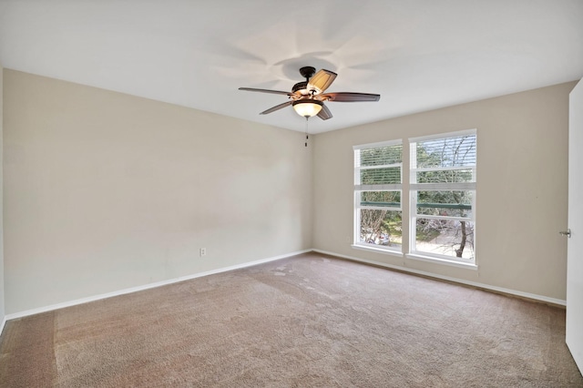 spare room featuring carpet, a ceiling fan, and baseboards