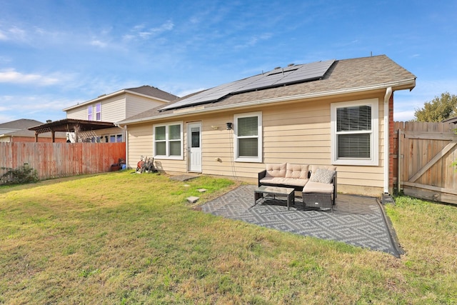 rear view of property with a patio, a fenced backyard, an outdoor hangout area, solar panels, and a lawn