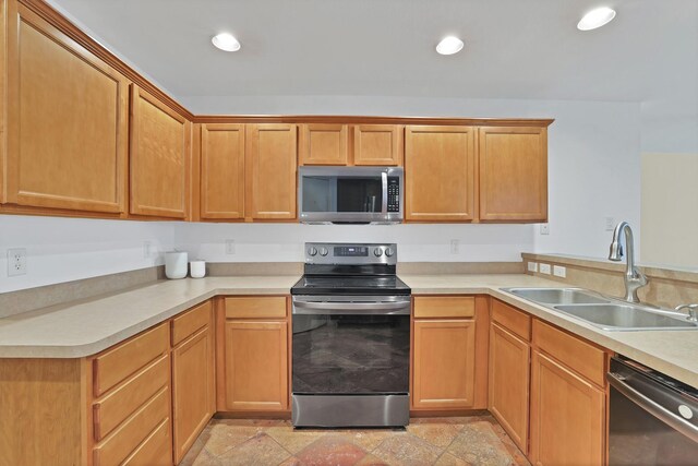 kitchen featuring ceiling fan, sink, kitchen peninsula, and stainless steel appliances