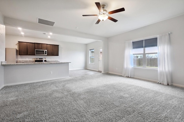 unfurnished living room featuring ceiling fan and light colored carpet