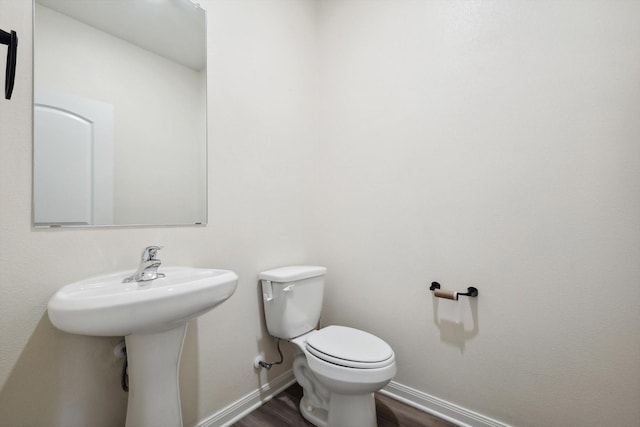 bathroom with hardwood / wood-style floors and toilet