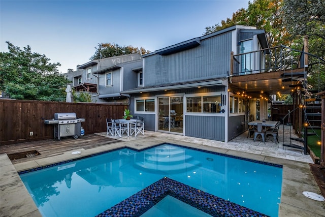 view of swimming pool with a wooden deck and grilling area