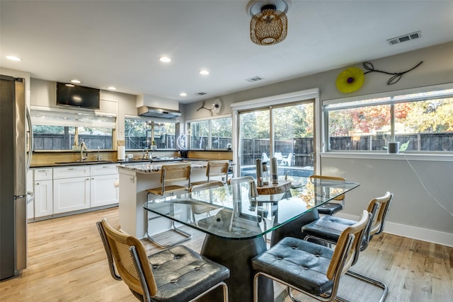 dining room with sink and light wood-type flooring