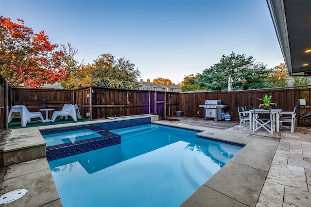 view of pool featuring a grill, an in ground hot tub, and a patio