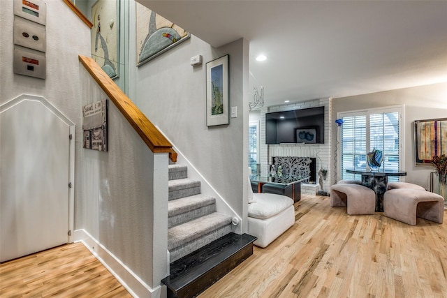 stairway featuring a fireplace and hardwood / wood-style floors