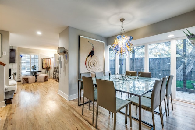 dining room with light wood-type flooring and a fireplace