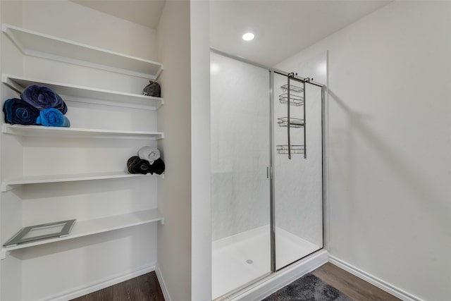 bathroom featuring an enclosed shower and wood-type flooring