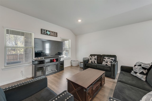 living room with light wood-type flooring and vaulted ceiling